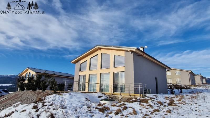 A cottage with large windows on a snowy hill in Dolná Lehota.