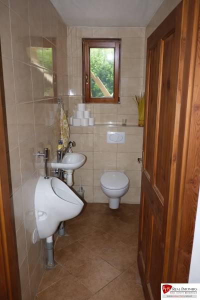 A small bathroom with a toilet, urinal, and sink in a three-room apartment.