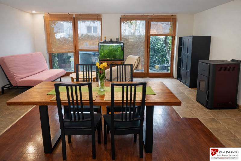 Dining room with balcony doors, an aquarium, and a table on a floor with a wood decor.