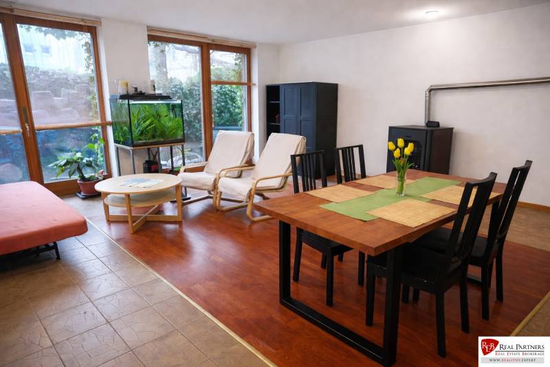 Living room in a three-room apartment with a wooden decor floor, a dining table, and an aquarium.