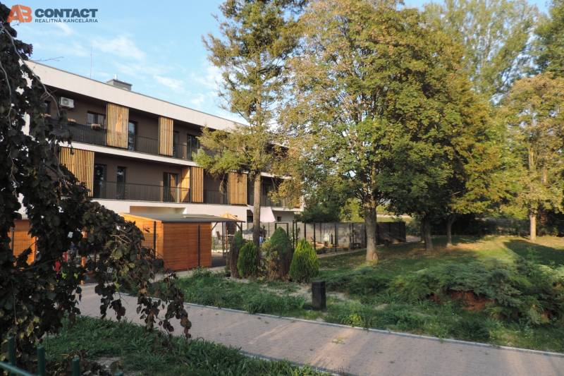 An apartment building on Bodona Street, surrounded by greenery and trees, ideal for studio living.