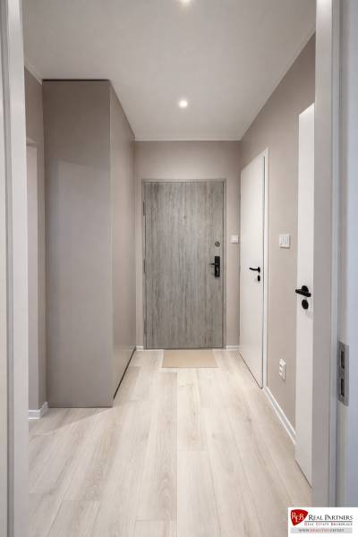 Entrance hallway with wood-patterned flooring in a 2-room apartment.