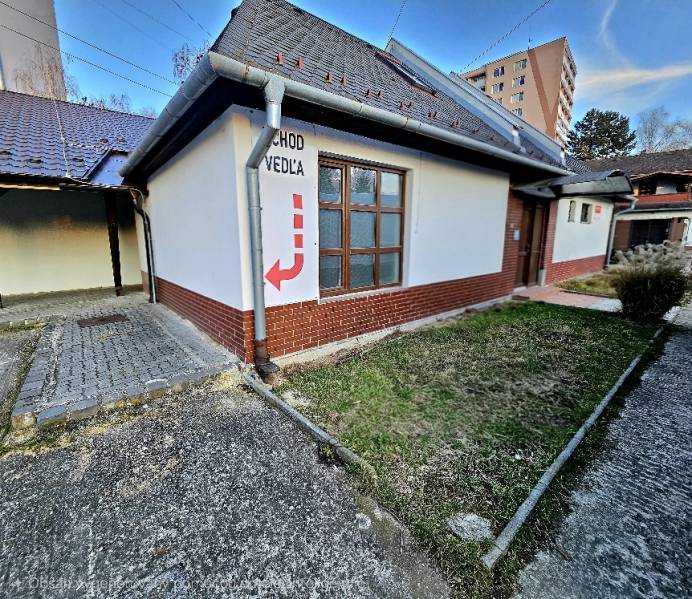 A building with a brick facade in Bánovce nad Bebravou, entrance label next door.