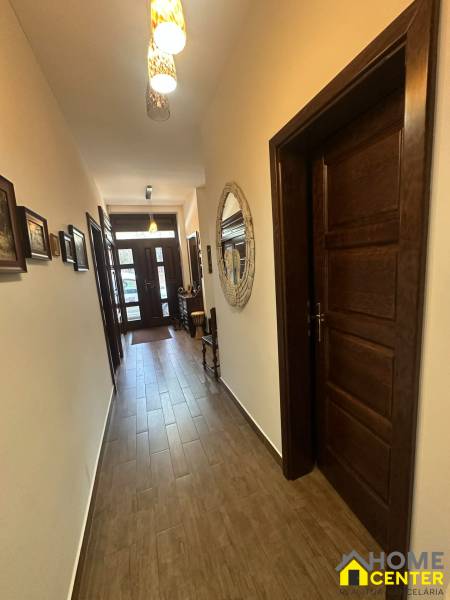 Hallway in a family house with a wooden decor floor and a decorative mirror on the wall.