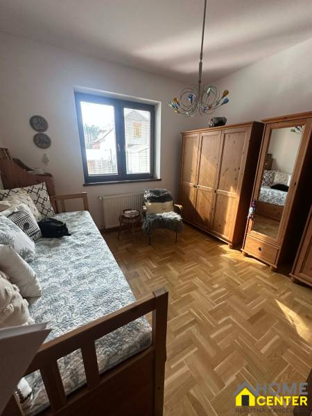 A room in a family house with a wooden decor floor and a bed.