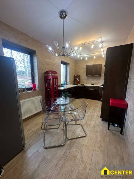 A kitchen in a family house with a wooden decor floor and a glass table.