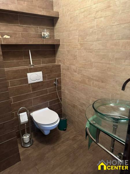 A bathroom in a family house with a wooden decor floor and modern toilet equipment.