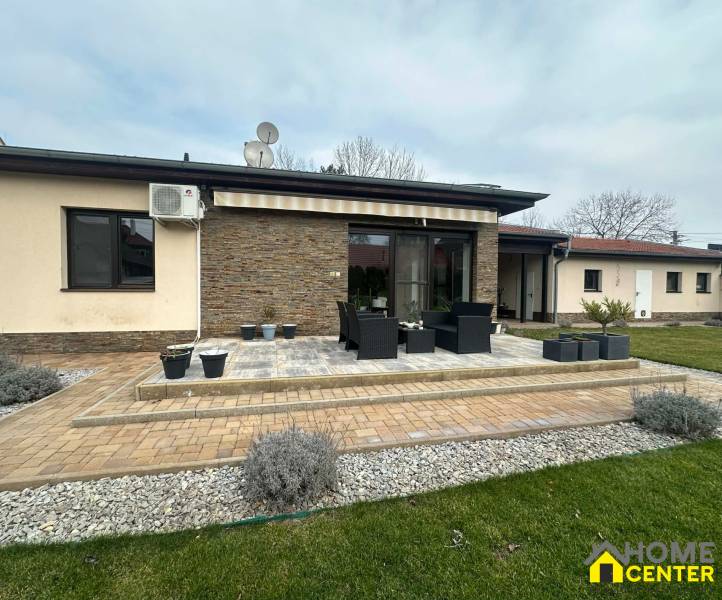 Terrace of a family house in Komárno with flower pots and outdoor seating.