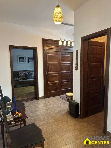 A hallway in a family house with a wooden decor floor and wooden doors.