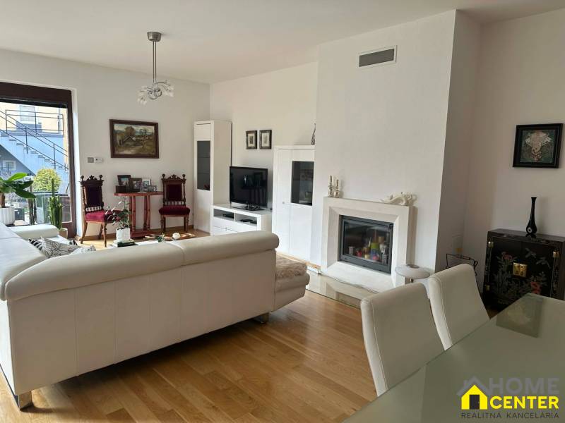 Interior of a family house with a fireplace, sofa, and wooden decor flooring.