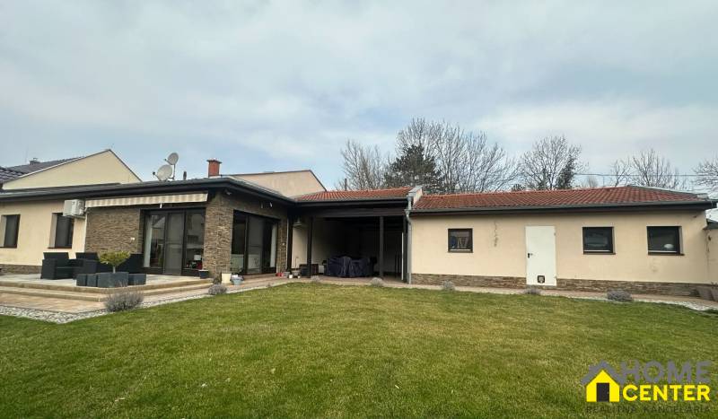 A family house in Komárno with a terrace, stone cladding, and a satellite dish on the roof.