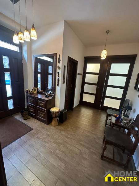 Interior of a family house with a wooden decor floor, storage space, and decorative lighting.