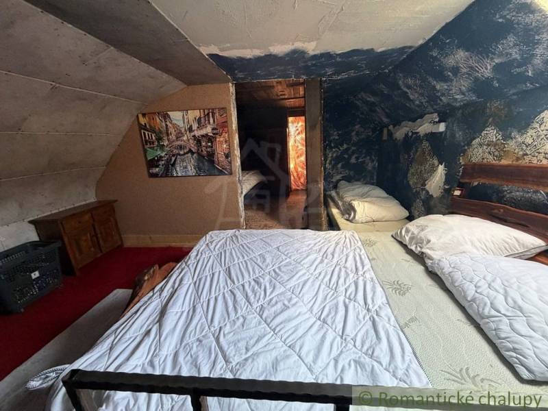 Attic bedroom in a family house with a painting and a blue wall full of patterns.