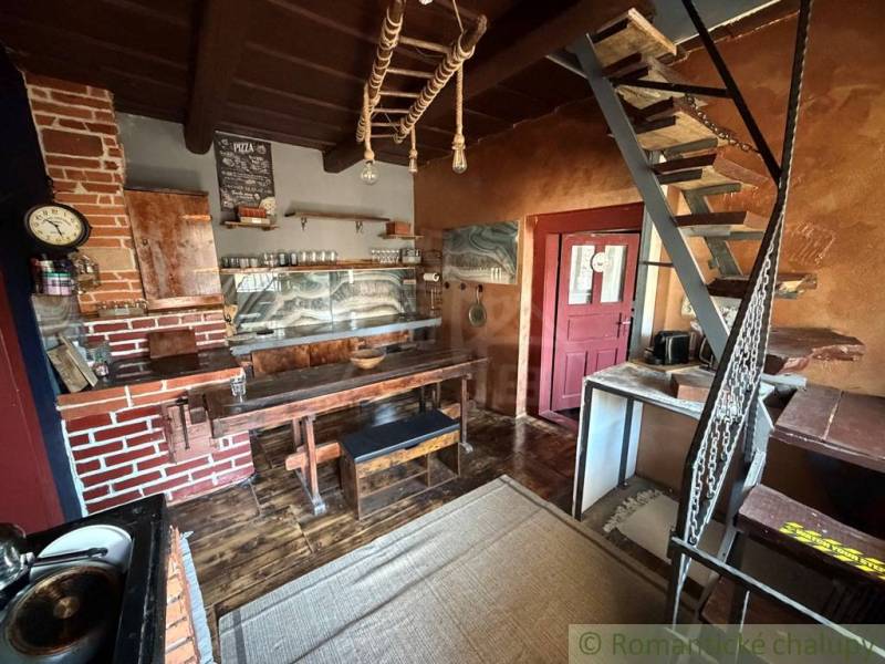 A kitchen in a family house with brick elements and a wooden decor floor.