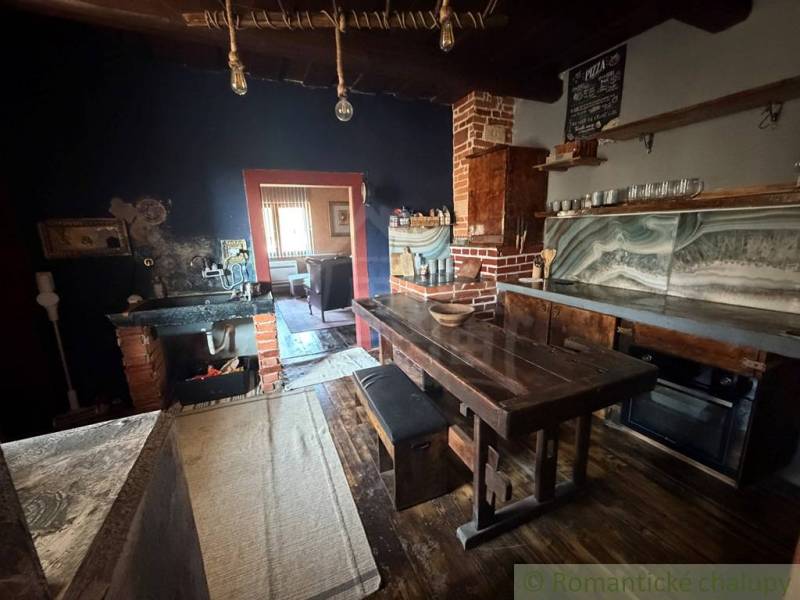 Rustic kitchen in a family house with a wooden table and brick detail.
