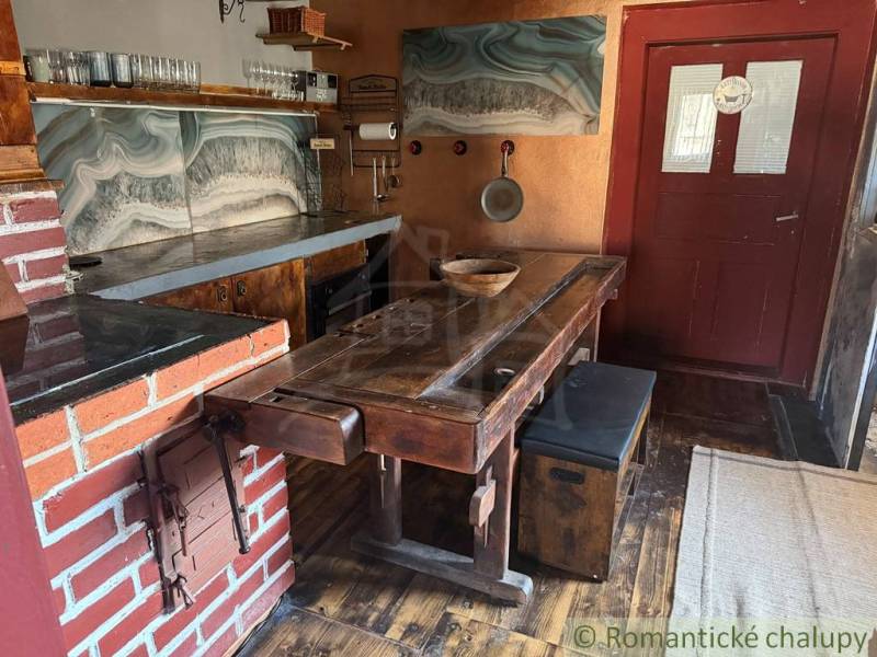 Rustic kitchen in a family house with brick details and a wooden decor floor.