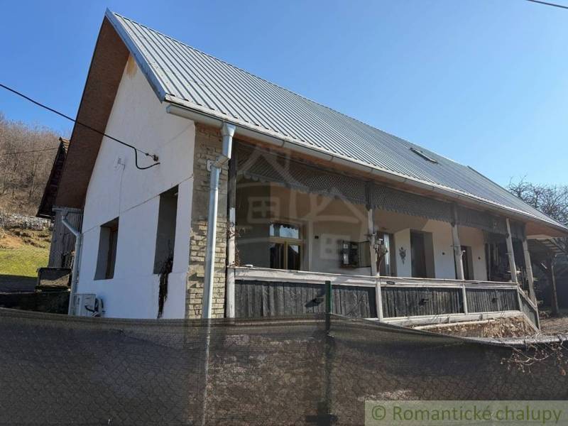 A family house in Ratkovské Bystré with a garden, white facade, and metal roof.