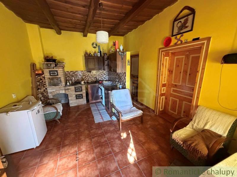 Yellow walls with traditional furniture, a tiled stove in a family house, a floor with a wooden decor.