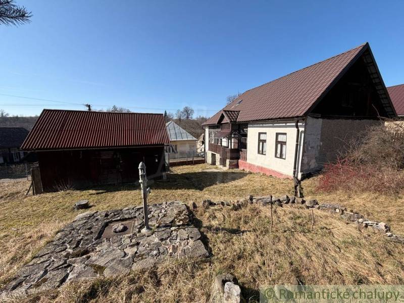 A family house in Lipovec with a stone well and a wooden annex in the yard.