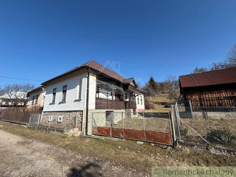 A family house in Lipovec surrounded by grass and a fence under a blue sky.
