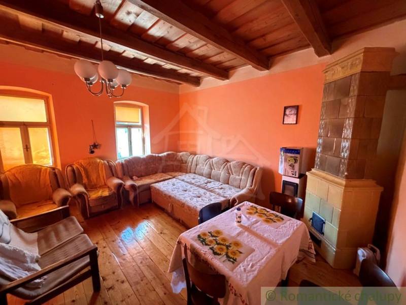 A living room in a family house with a tiled stove and a floor with a wooden decor.