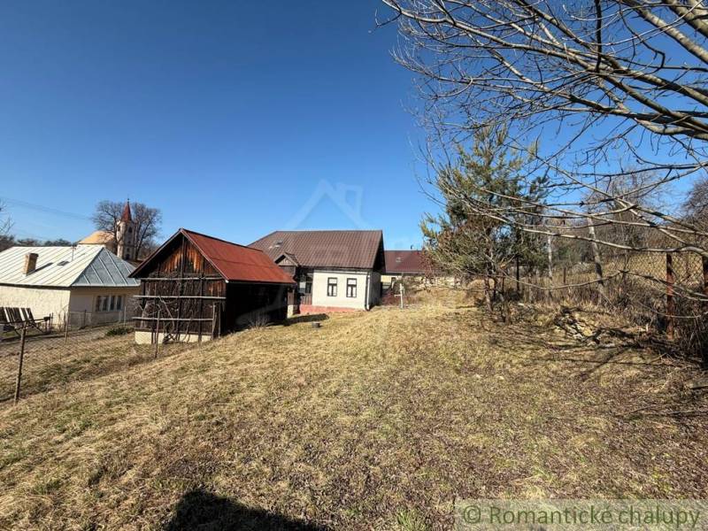 A family house in Lipovec with a wooden shelter and trees on the property.