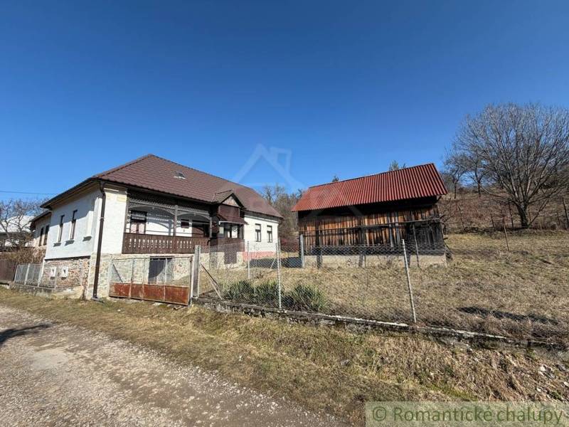 A family house in Lipovec with an adjacent building, fenced plot, clear sky.