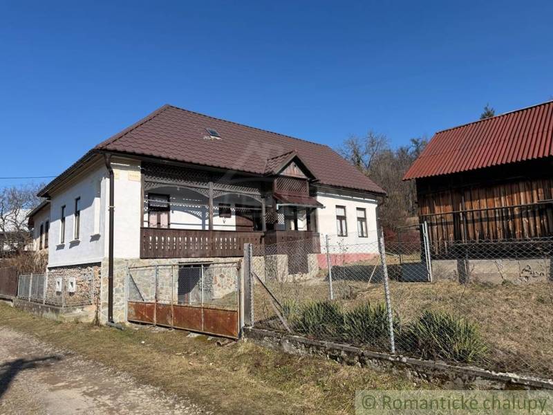 A family house in Lipovec with a stone foundation, wooden details, and a metal roof.