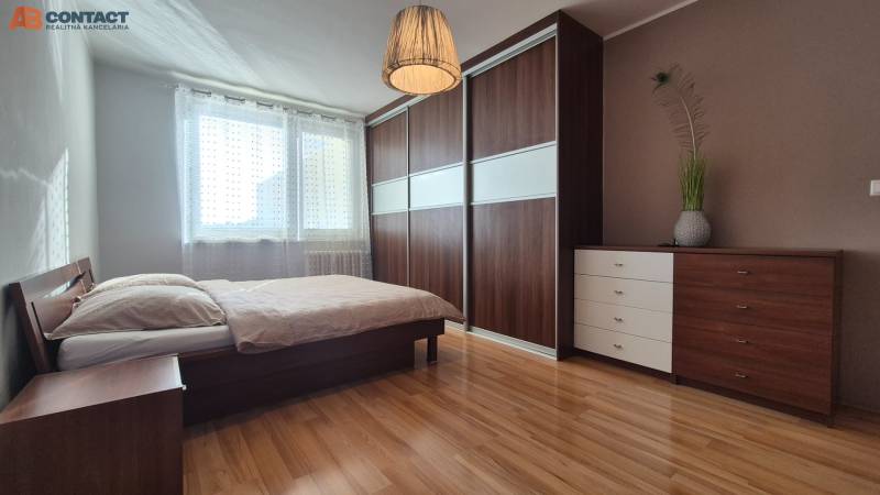 Bedroom with a bed and built-in wardrobe, 2-room apartment, floor with wood decor.