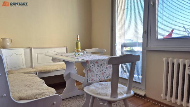 Dining area in a 2-room apartment with a wooden decor floor.