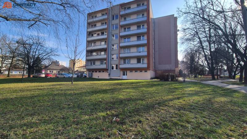 An apartment building on Bratislavská Street in Piešťany surrounded by greenery and trees.