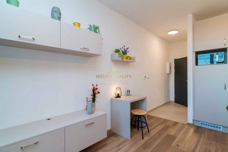 Interior of a 1-room apartment with light furniture and a wooden decor floor.