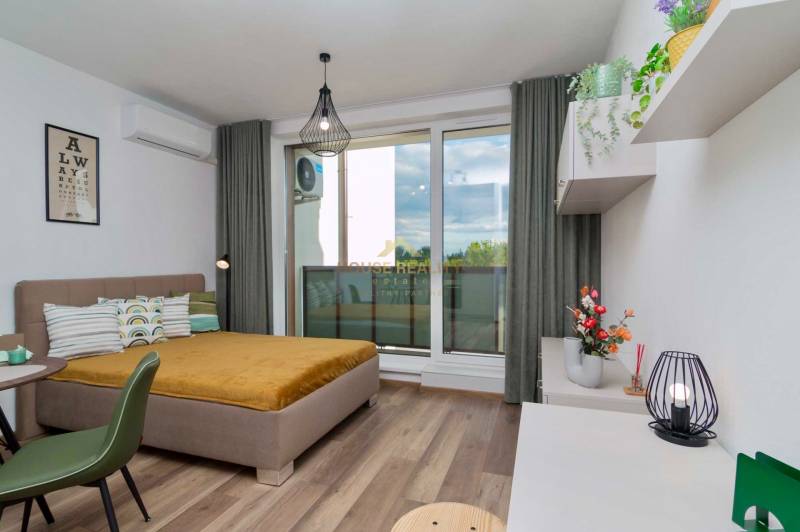 1-bedroom apartment with wood-patterned flooring, modern lighting, and a view of the terrace.
