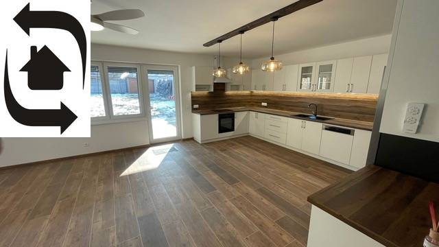 A kitchen in a family house with wooden floor decor and modern lighting.