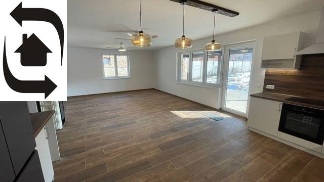 Spacious living area with wood-patterned flooring in a family house.