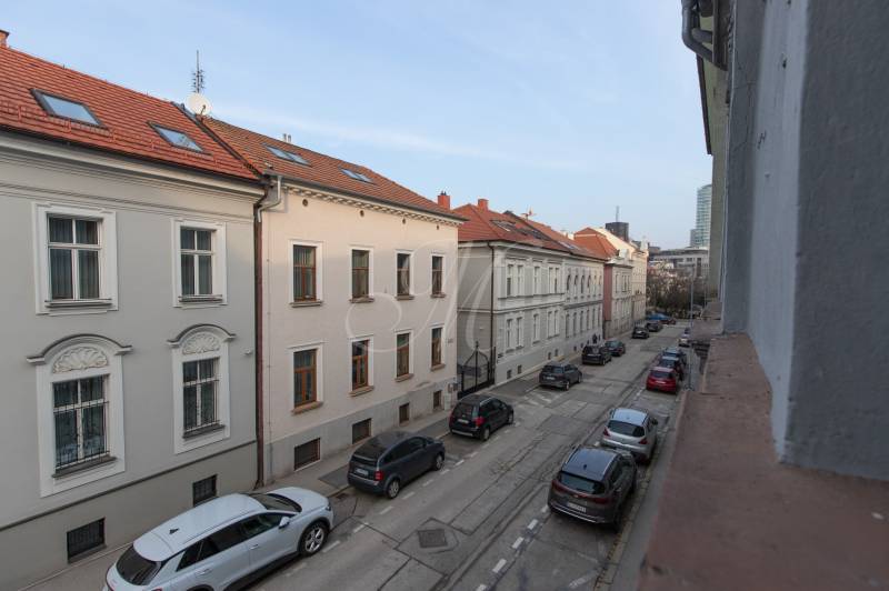A view of Leškova Street in Bratislava - Old Town with a row of cars.