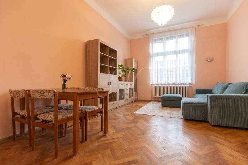 Living room with a sofa, table, and wooden decor flooring in a 3-room apartment.
