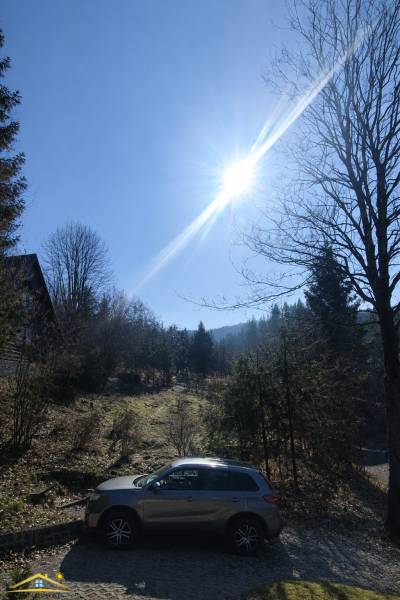 A sunny day at the cottage in Oščadnica, a car parked in a natural setting.