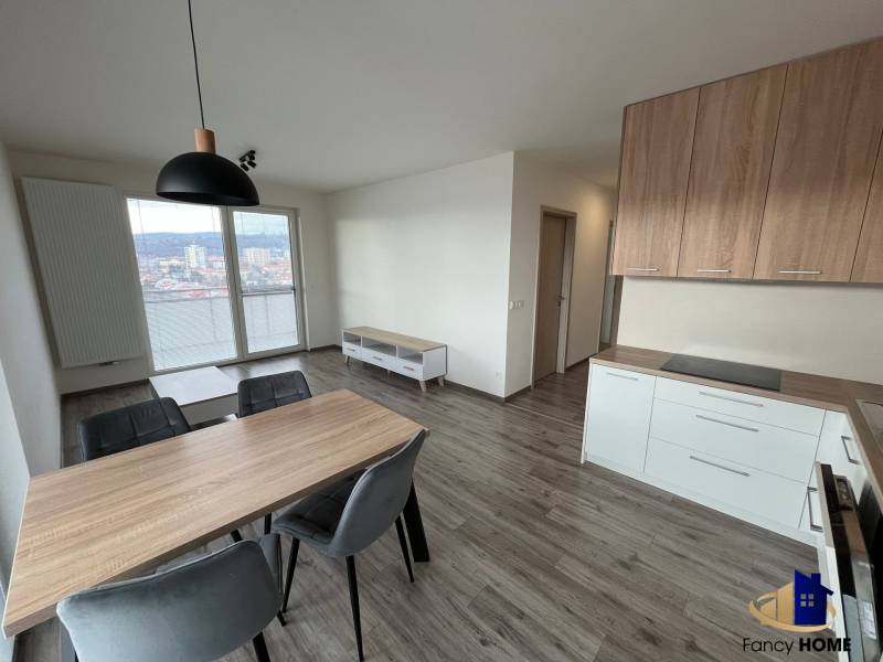 Dining area with wood-patterned flooring in a 3-room apartment, kitchen unit, and view.