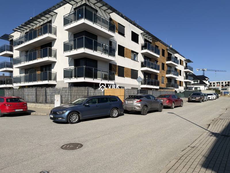 New apartment buildings on Topoľčianska Street in Košice, Západ district, with cars parked in front.