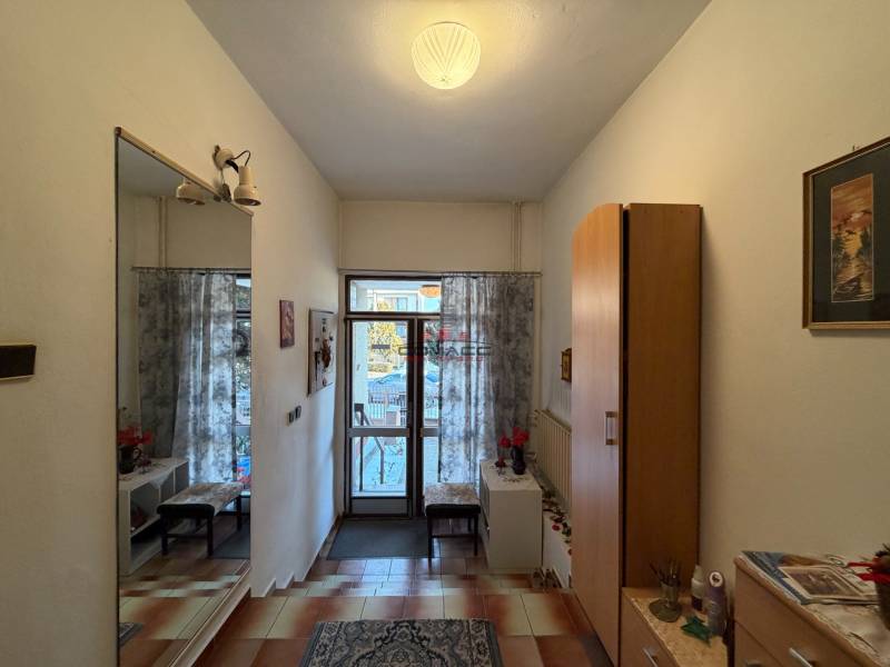 Entrance hall in a family house with tiles, a mirror, and decorative lighting.