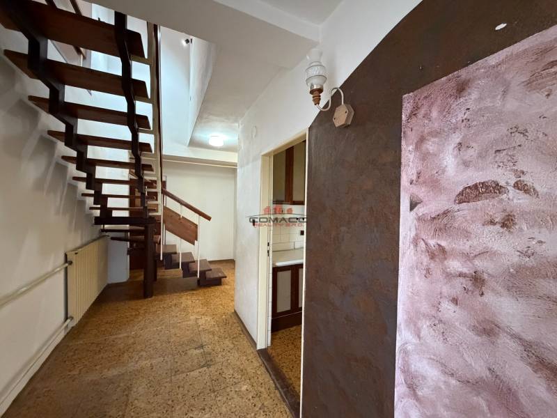 A hallway with open stairs in a family house, floor with wooden decor.