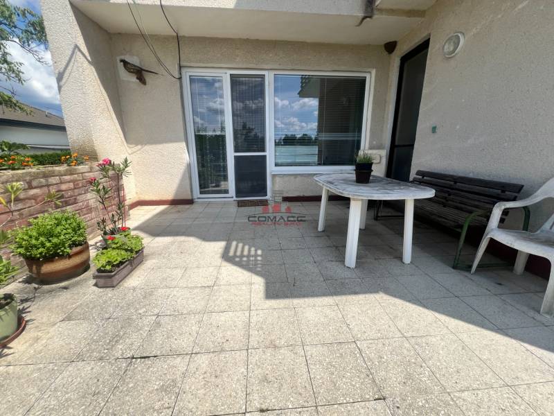 The terrace of a family house on Tálová Street in Veľké Orvište with a plastic table and flowers.