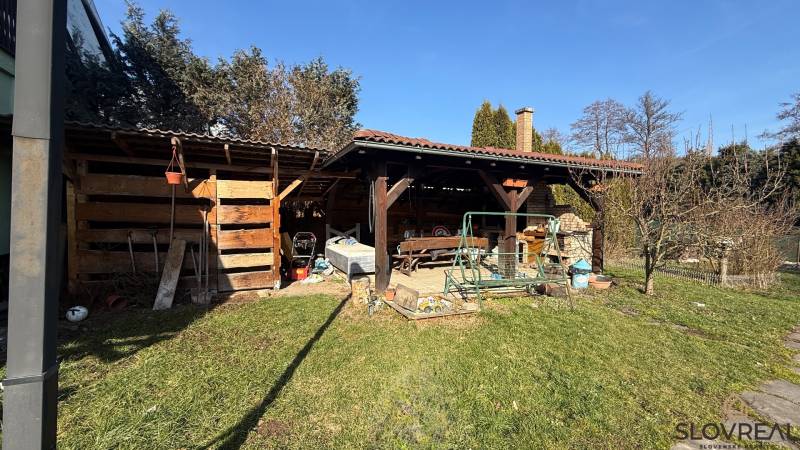 The garden of a family house in Lutila, with a wooden shelter and a swing on the property.
