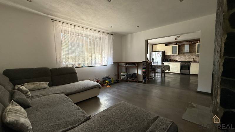Living room in a family house with a view of the kitchen, floor with wood decor.