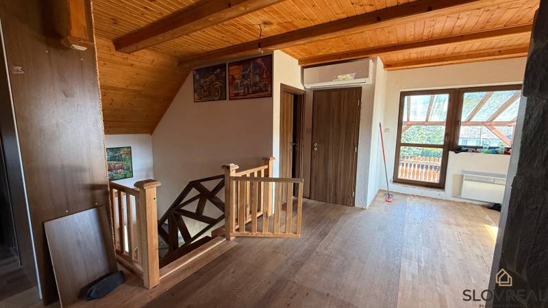 A hallway in a family house with a wooden decor floor and wooden railing.