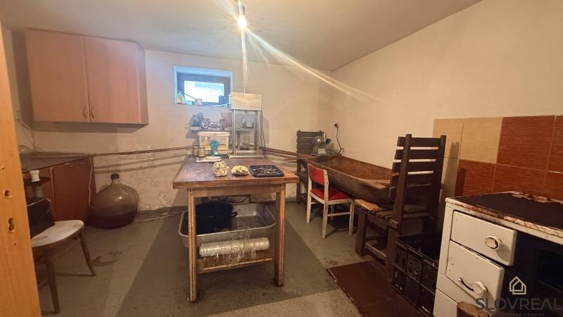 A kitchen in a family house with simple furniture and food processing equipment.