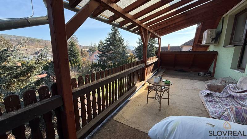 A wooden terrace of a family house in Lutila with a view of the garden and trees.