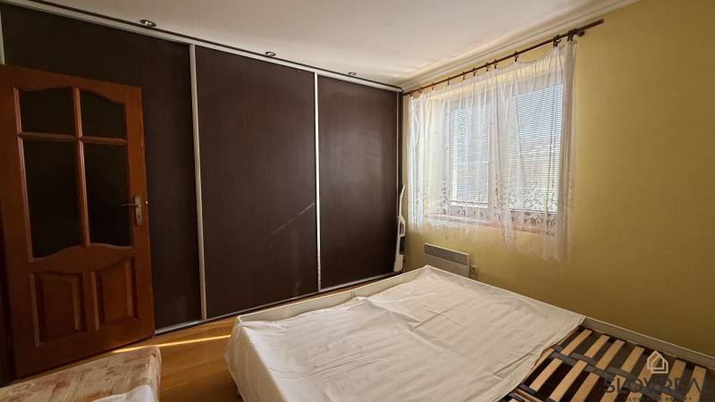 Bedroom interior in a family house with a large built-in wardrobe and a bed.