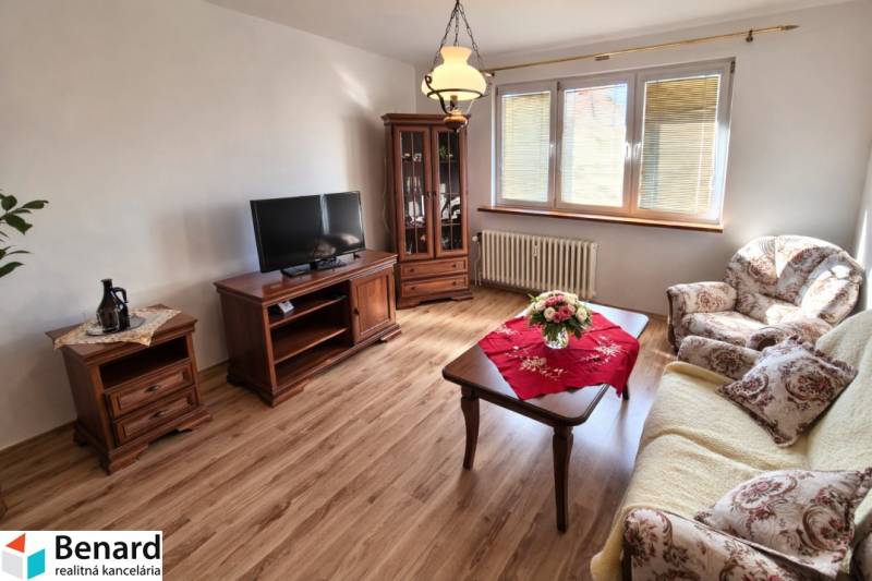 Living room in a 2-room apartment with a wooden decor floor and classic furniture.